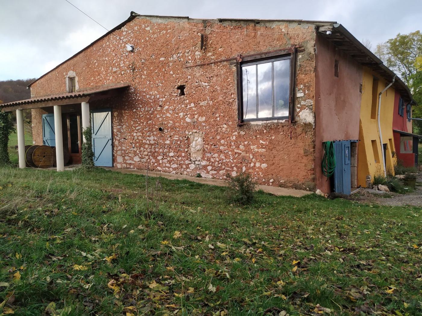 Le pignon de la grange en pisé et galets, derrière la maison