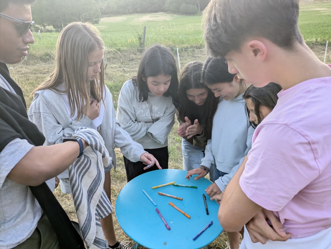 Groupe d'enfants rassemblés autour d'une table pour un jeu, dehors
