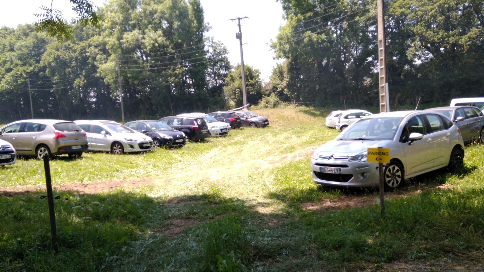Le parking aménagé dans le pré, à l'entrée du hameau