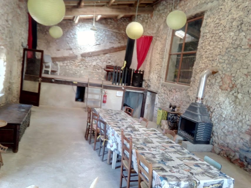 La salle à manger en longue tablée avec poêle à bois