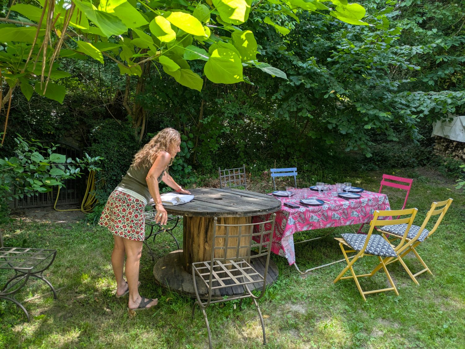Valérie dressant la table sous la pergola